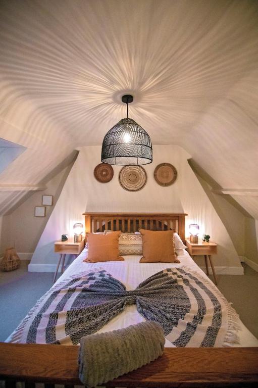 a bedroom with a bed with a bow tie on it at Nadder Lodge - Salisbury in Old Sarum