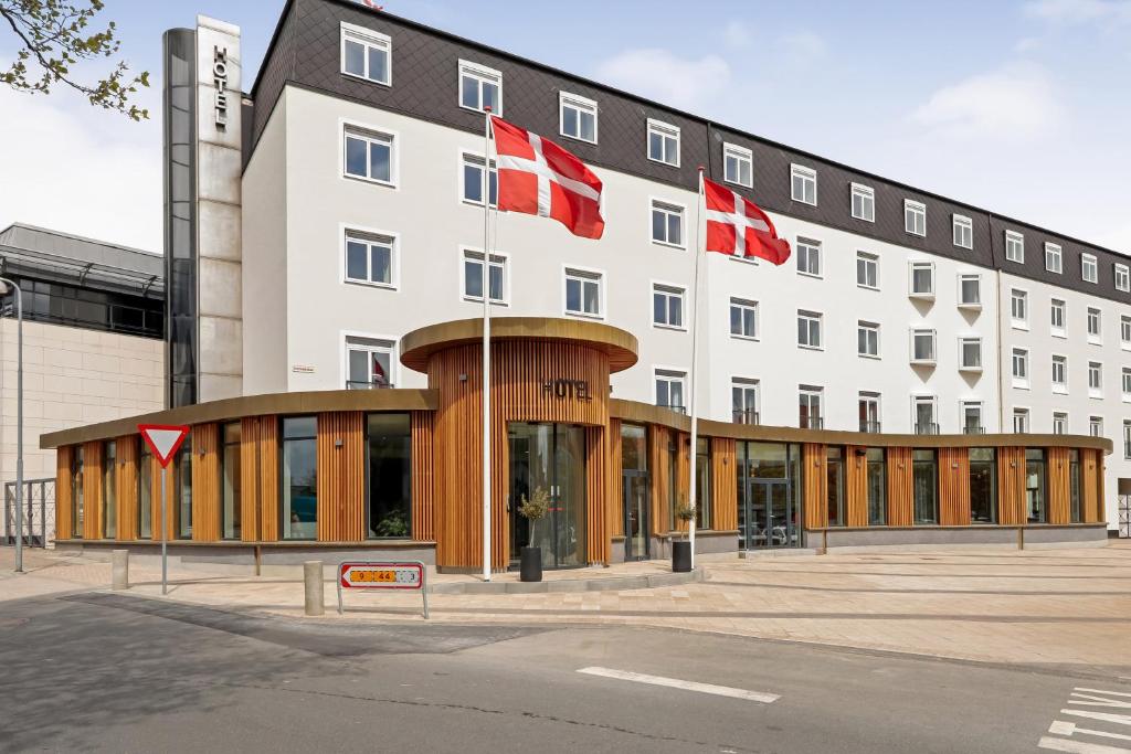 a building with two canadian flags in front of it at Hotel Svendborg in Svendborg