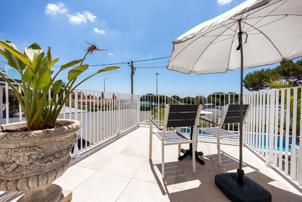 a patio with two chairs and an umbrella at BeGuest Estoril Guesthouse in Estoril