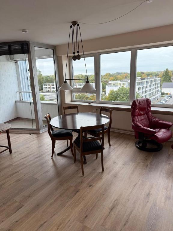 a living room with a table and chairs and windows at Palaceblick in Schleswig