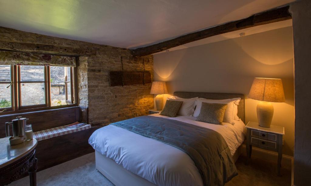 Un dormitorio con una cama y un escritorio y una ventana. en The Angel at Burford, en Burford