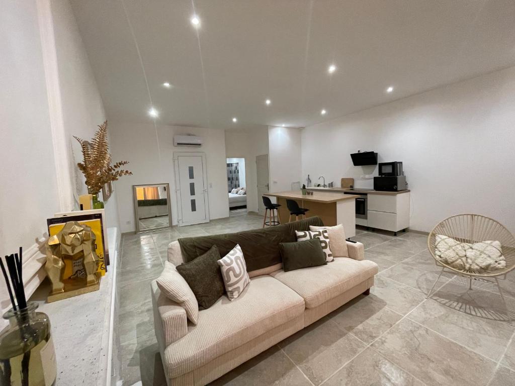 a living room with a couch and a kitchen at Appartement avec mini suite vue Cathédrale in Cavaillon
