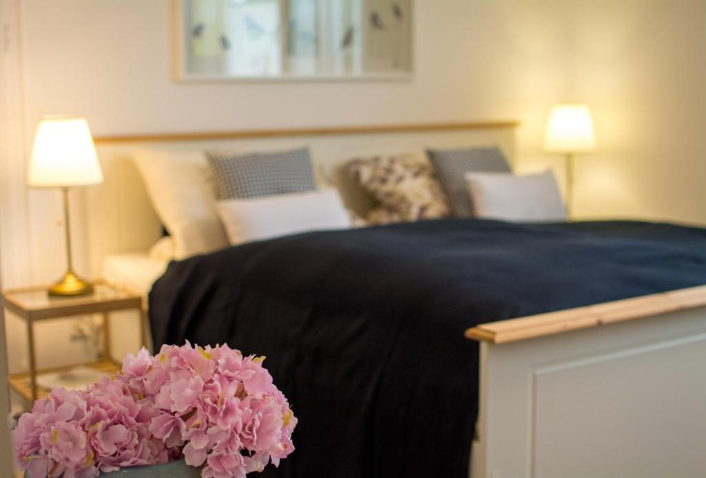 ein Schlafzimmer mit einem Bett mit einer schwarzen Decke und rosa Blumen in der Unterkunft Eulennest-OWL in Bad Salzuflen
