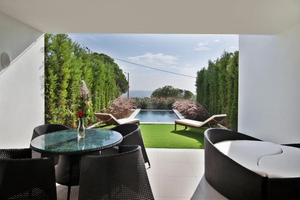 a patio with a table and chairs and a pool at Sao Rafael Holidays in Albufeira