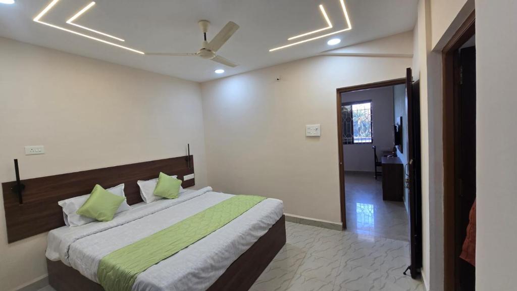 a bedroom with a large bed with green pillows at I Rose Guest House By Olive in Talaulim
