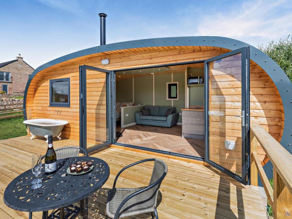 a tiny house on a deck with a table and chairs at 1 Bed in Matlock oc-96256 in Crich