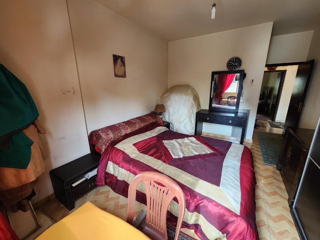 a bedroom with a bed and a chair and a mirror at Cozy Stay in Baabda