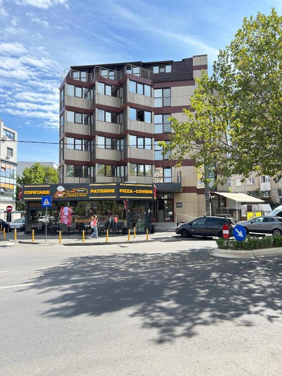 a parking lot in front of a tall building at Acomodoro Residence in Bucharest