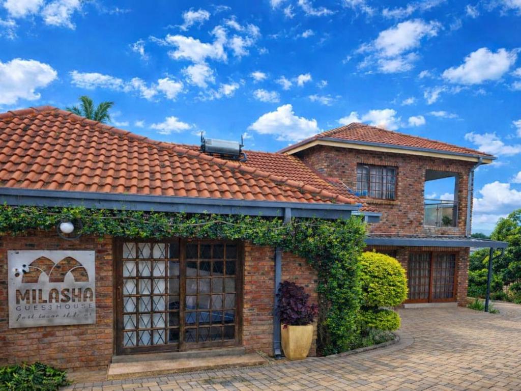 a brick building with a red roof at Milasha Guest House in Louis Trichardt