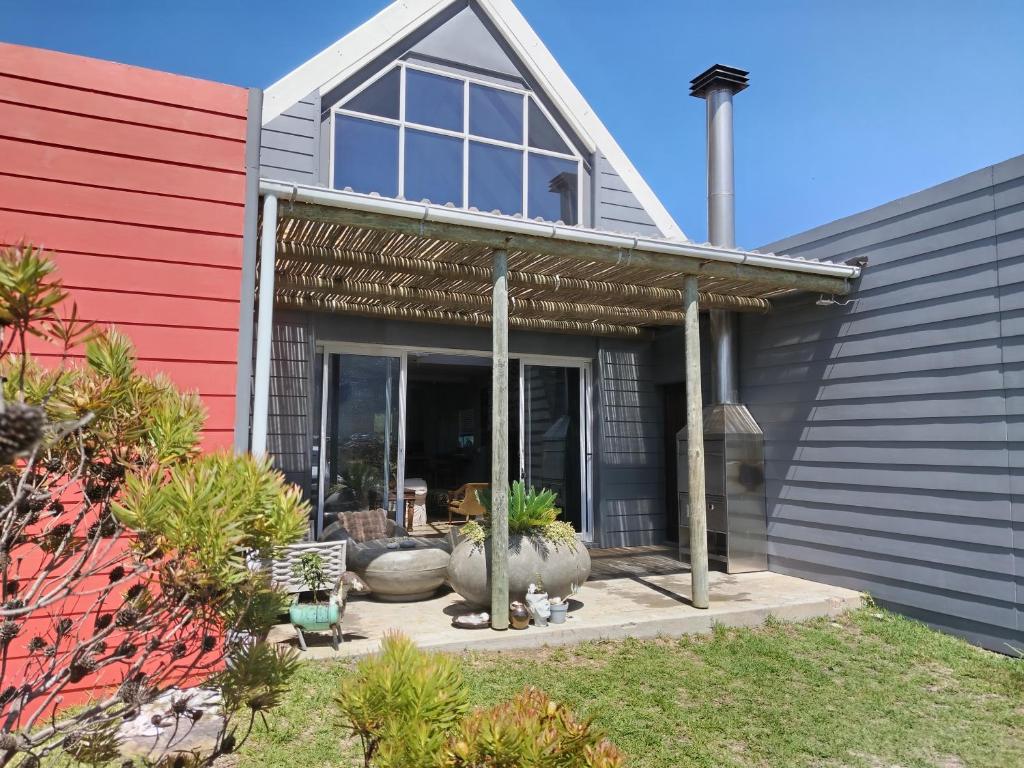 a home with acovered patio with plants in the yard at Mountain View in Bettyʼs Bay