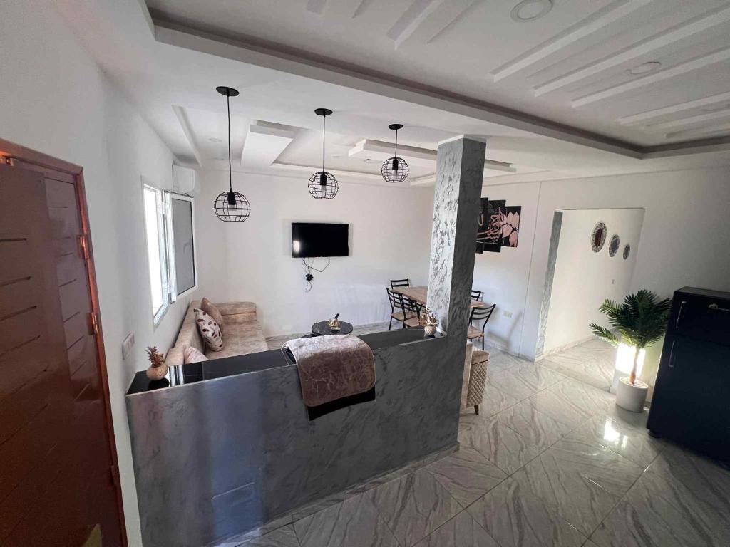 a bathroom with a tub and a television in a room at Villa 2 in Al Maqārisah