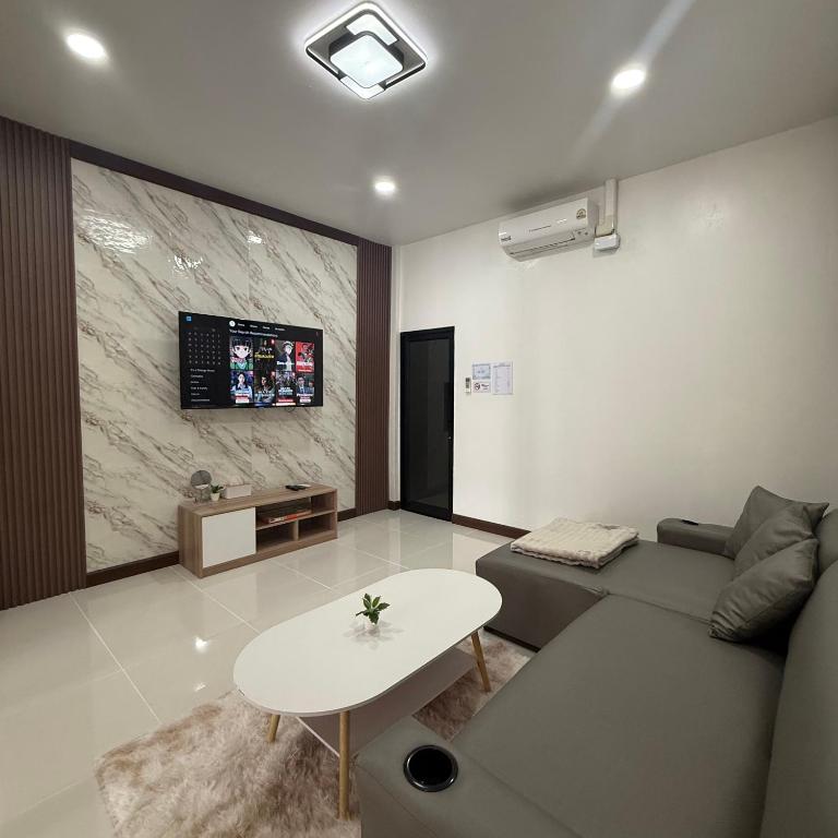 a living room with a couch and a table at O Pha Suk House in Hat Yai