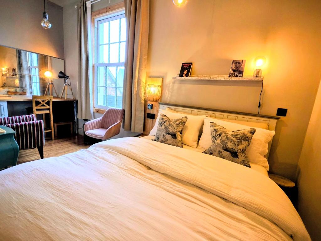 a bedroom with a large white bed with two pillows at The Pheasant in Broseley