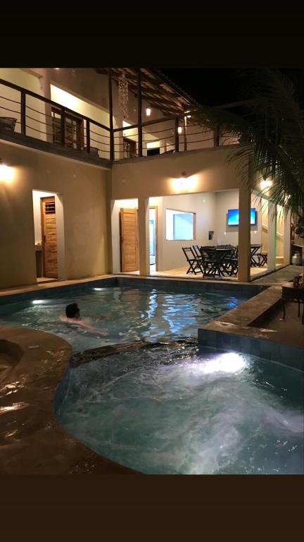 a person swimming in a swimming pool at night at Rekanto Sabiá in Jijoca de Jericoacoara