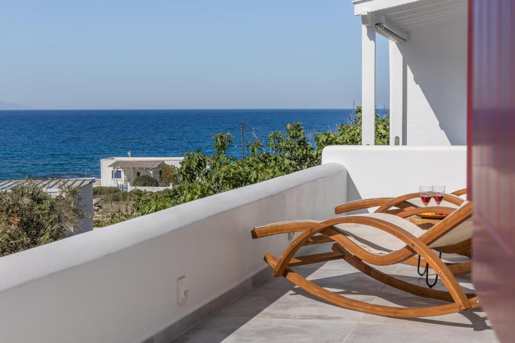 two chairs sitting on a balcony overlooking the ocean at Glaucus Summer House sea view in Mandrakia