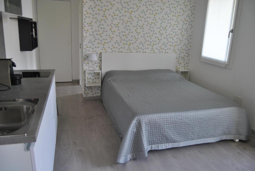 um pequeno quarto com uma cama e um lavatório em A Zonzo em Vicenza