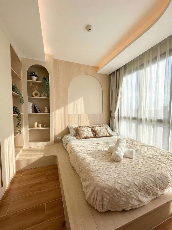 a bedroom with a large bed and a window at Fantasea Condo Kamala in Kamala Beach