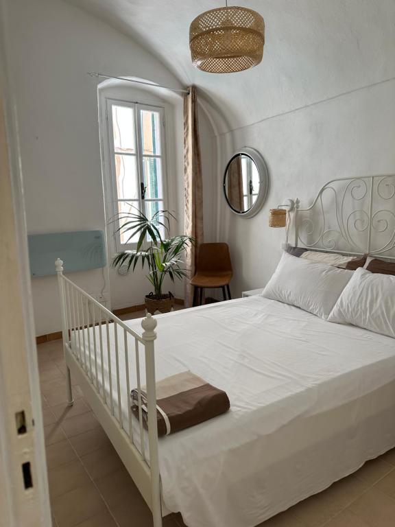 a bedroom with a white bed and a window at Casa Andrée in Sanremo