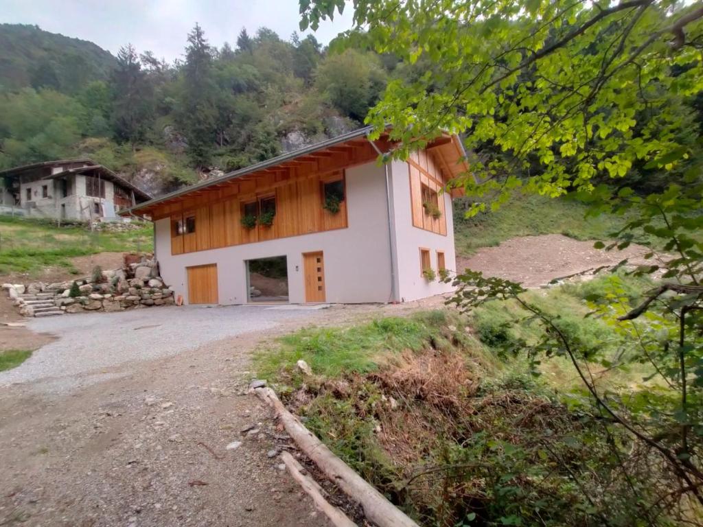 a house on a hill next to a dirt road at B&B Le Origini in Ledro