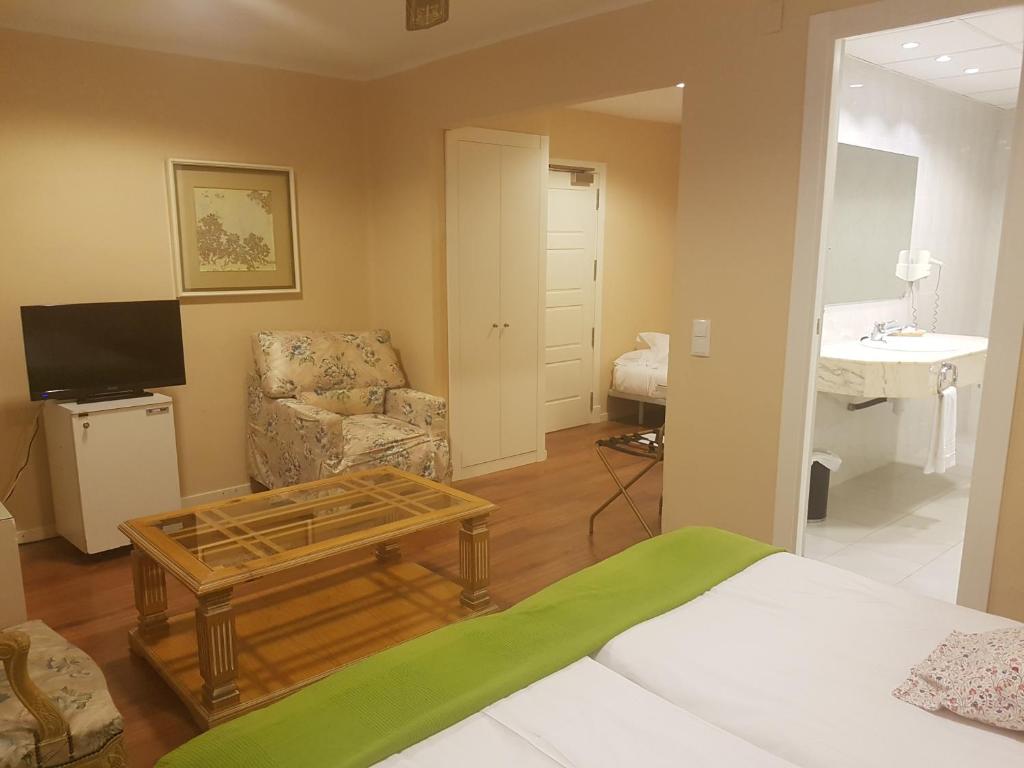 Habitación con cama, silla y mesa. en Hotel del Carme, en Vilagrassa