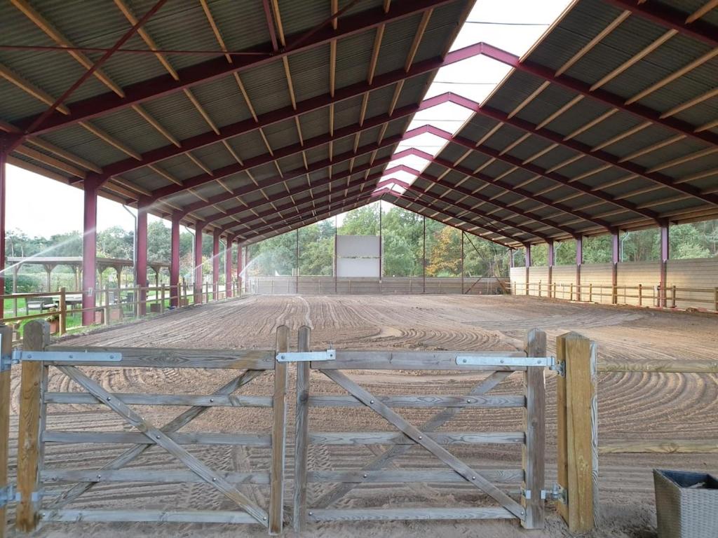 an empty barn with a fence in the middle at Relaxed Guesthouse in Heibloem