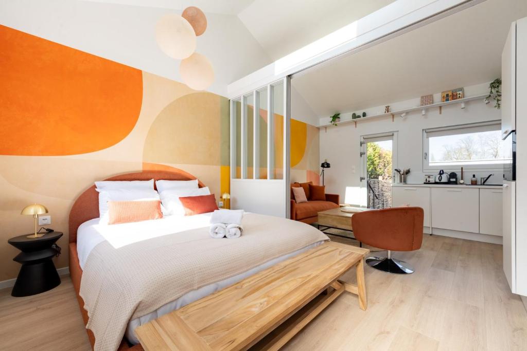 a bedroom with a large bed and a kitchen at Air Nomad • Séville in Valenciennes