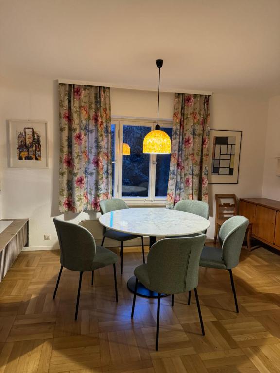 a dining room with a table and chairs and a window at Greenhouse in Fellbach