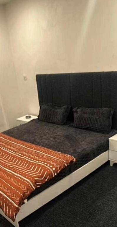 a bed with a black headboard in a room at موتيل رويا in Erbil