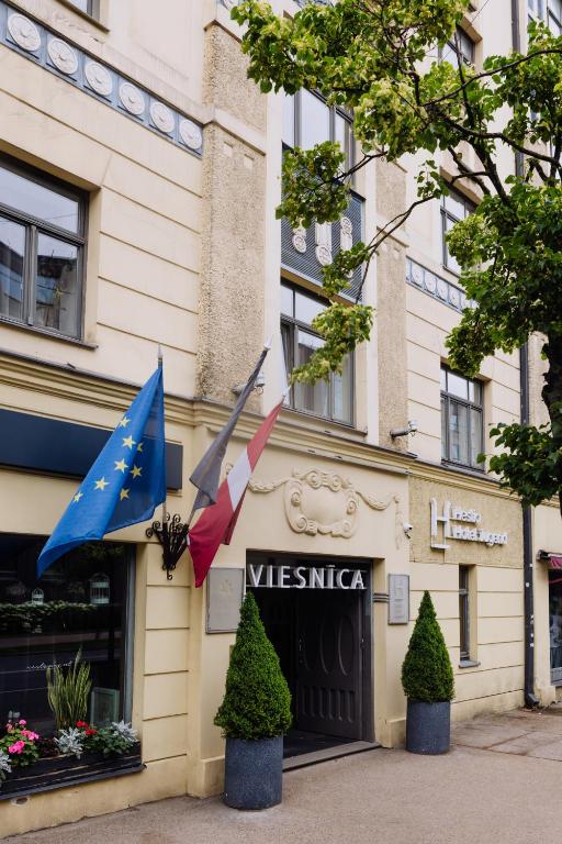 a building with two flags in front of it at Hestia Hotel Jugend in Riga