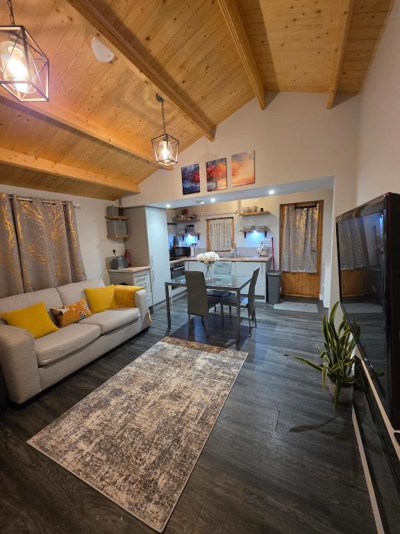 a living room with a couch and a table at Secluded Log Cabin escape in High Wycombe