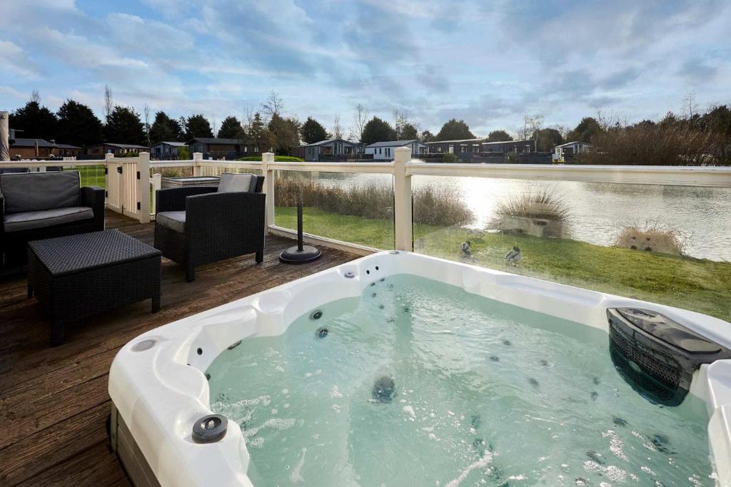 a jacuzzi tub sitting on a deck with at Lakeside Gem with Hot Tub in York