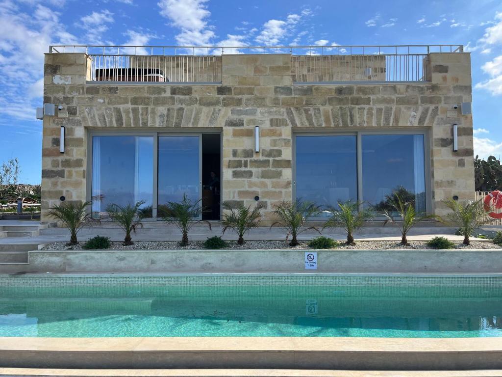 a house with a swimming pool in front of it at Villa Lippia in Misraħ Miel