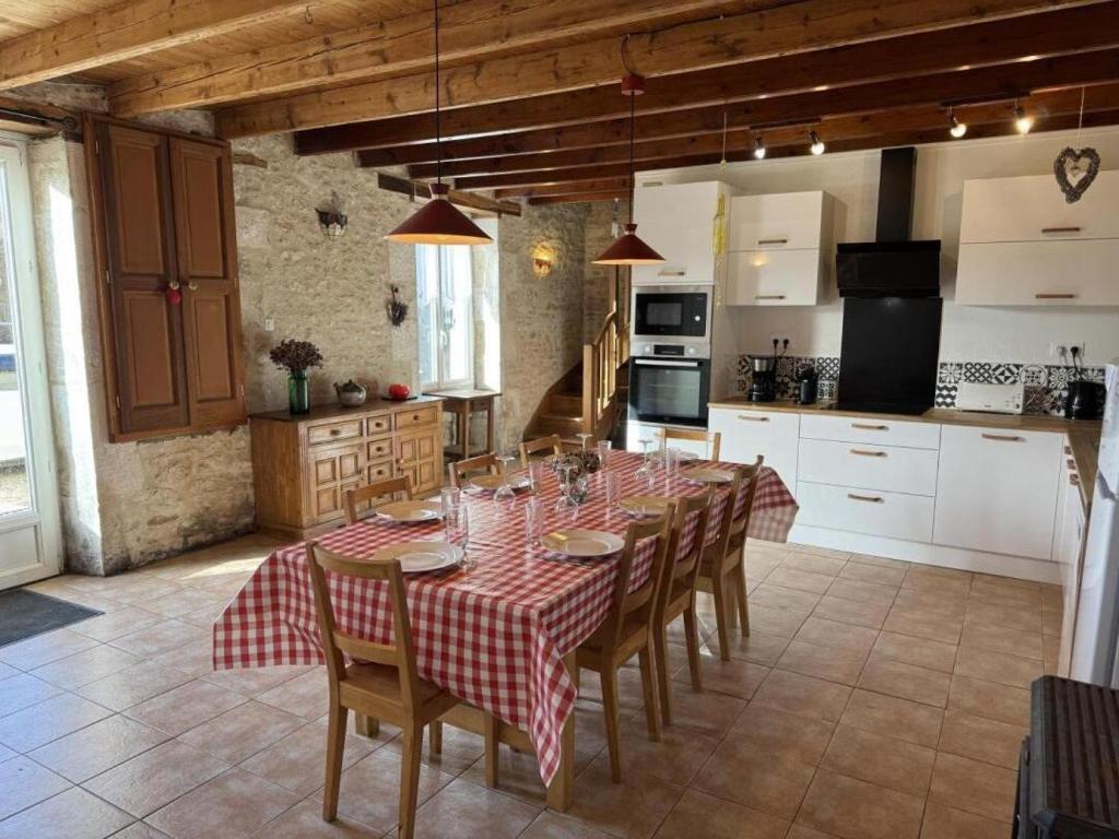 a kitchen with a table and chairs in a kitchen at Les volets bleus in Saint-Saviol