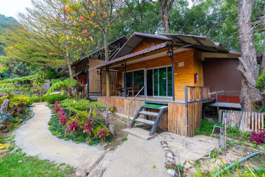 a small wooden house with a staircase in a garden at อินทนนท์ขุนเล่าลือ in Ban Na Yang