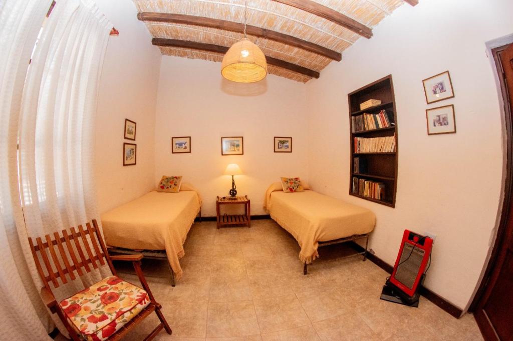 a room with two beds and a chair in it at Tilcara Casa con 3 dorm Pedacito de Cielo in Tilcara