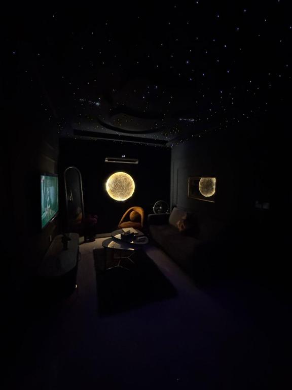 a dark room with a bed and a television at Moonlit Cinema Suite in Lahore