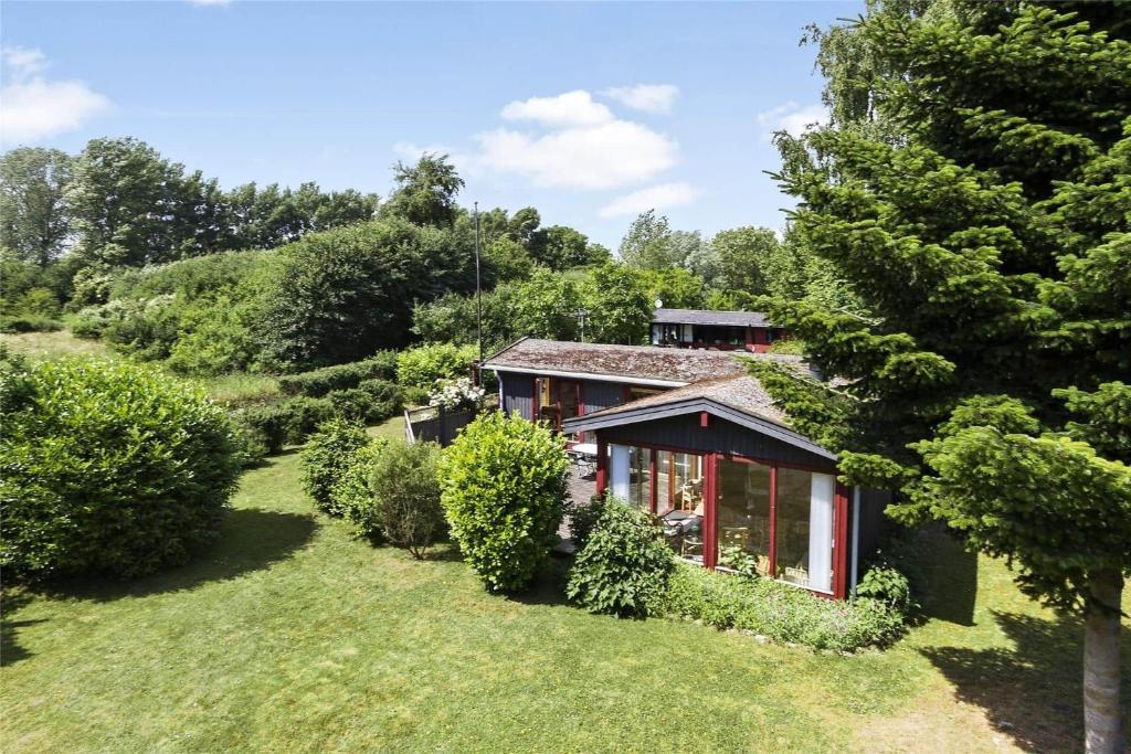 a house in the middle of a yard with trees at 3055-Stege-Stejlepladsen-23 in Stege