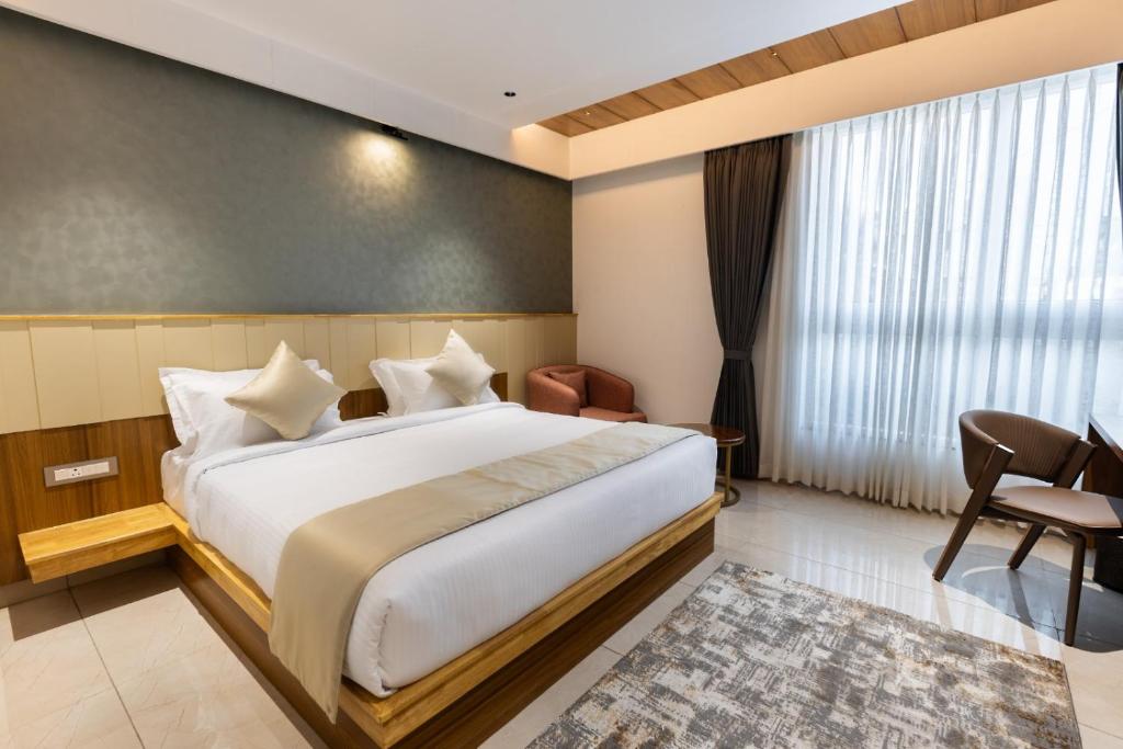 a bedroom with a bed and a chair and a window at AIRA Boutique Hotel in Bangalore