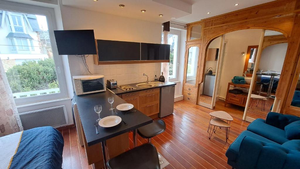 a living room with a kitchen with a counter top at Studio à 70m des flots in Trébeurden