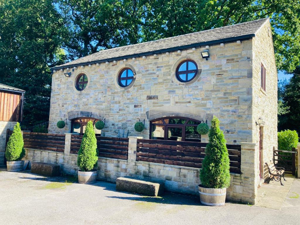 a small stone building with a bench and windows at Pingle Nook Barn on the Farm - Denby Dale in Huddersfield