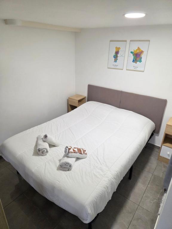 a bedroom with a bed with shoes on it at L'auberge de Sucy - Studio Climatisé in Sucy-en-Brie