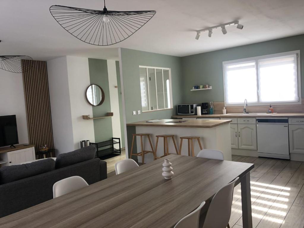 a kitchen and a living room with a table and a couch at Dom & Val in Tournan-en-Brie