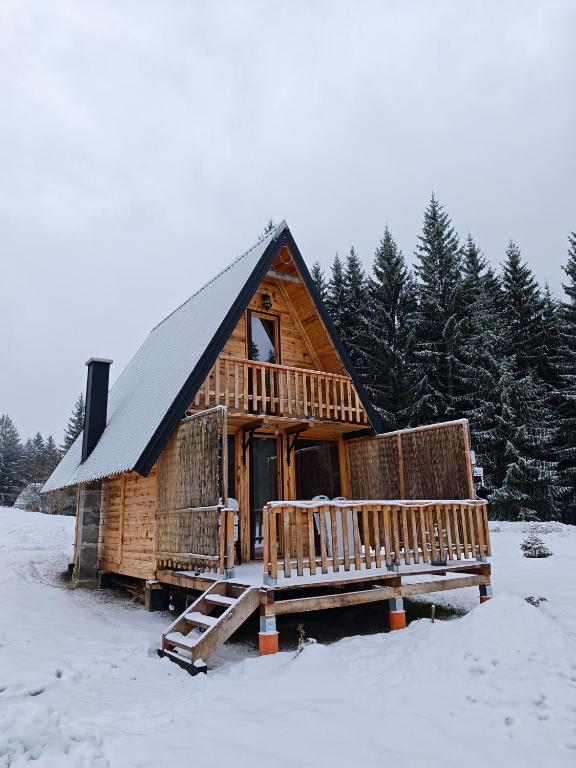a log cabin in the snow with a porch at Brvnara Panda Tara in Rača