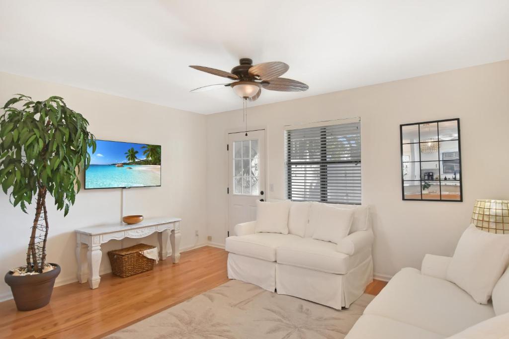 a living room with white furniture and a ceiling fan at Villa Leo in Saint Simons Island