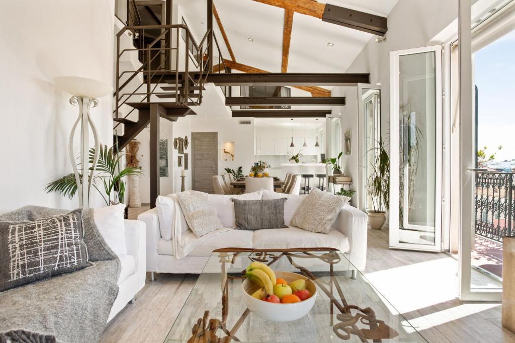 a living room with a couch and a table with a bowl of fruit at Duplex ForVille in Cannes