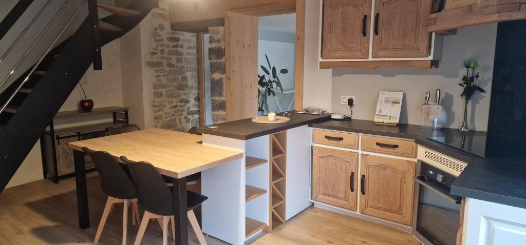 a kitchen with a table and a counter top at La maison de Morgane in Tourmont