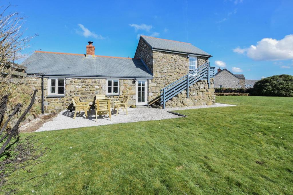 a stone house with two chairs and a table at 3 Bed in Sennen oc-thbyre in Sennen