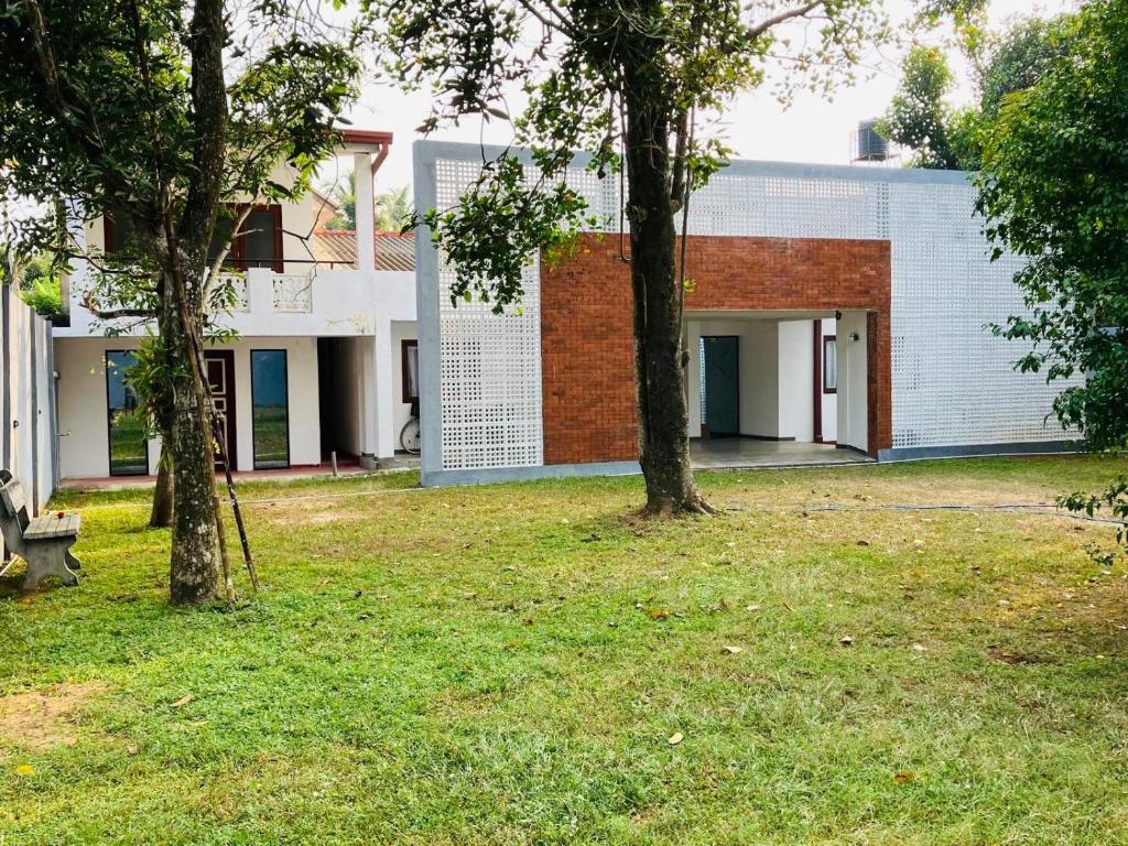 a building with two trees in a yard at Seth Villa Matara in Matara
