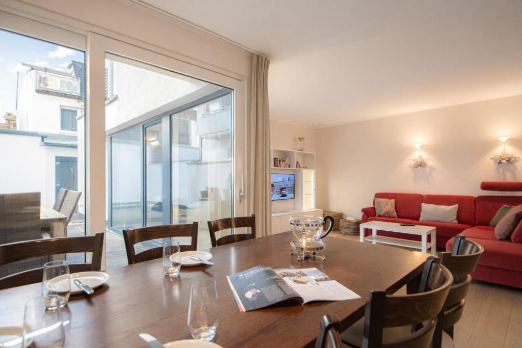 a dining room with a table and a red couch at Ferienwohnung Meeresrauschen in Norderney