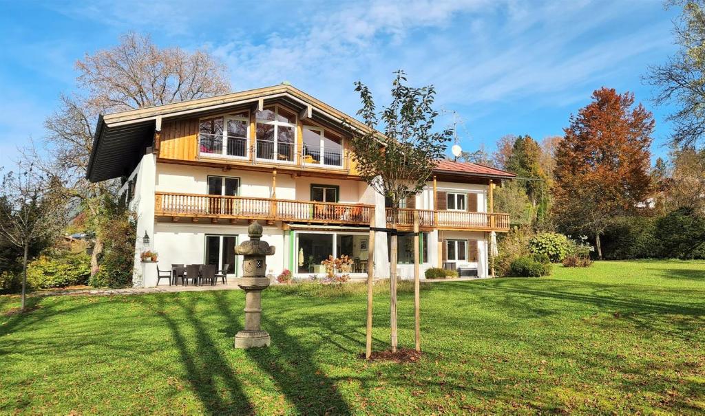a large house on a green yard with a house at Villa Marga Ferienwohnung Jenner in Schönau am Königssee
